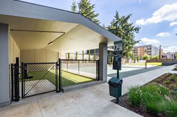 A modern building with a white roof and a black gate.at Traditions at Hazelwood, Portland, 97216